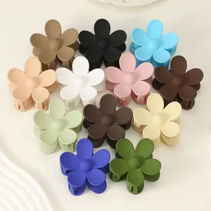 Multiple matte flower hair claw clips in various colors arranged on white surface