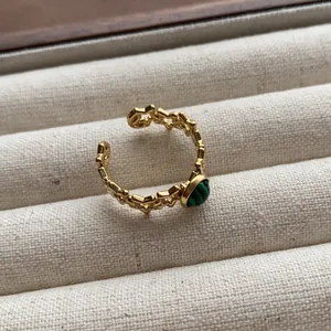 Close-up of retro gold star ring with green malachite stone inlay