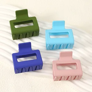 Close-up detail of four large matte square hair claw clips in a colorful assortment set