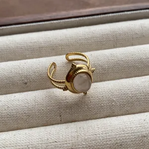 Macro detail of a vintage gold-tone ring featuring an oval translucent gemstone inlay.