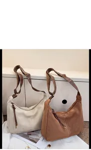 Vue détaillée de grands sacs à bandoulière rétro en daim coloris beige et marron