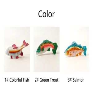 Detailed view of three fish-shaped acetate hair claws in trout and salmon patterns.