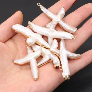 Vue détaillée de pendentifs en forme de croix en perles d'eau douce avec bords dorés