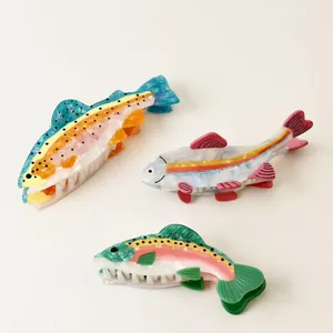 Close-up of three colorful fish-shaped acetate hair claw clips on a clean white background.