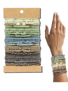 Detailed view of Bohemian elastic hair ties and braided bracelets on card and wrist.