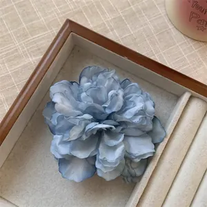Gros plan détaillé d'une pince à cheveux pivoine bleue vintage en boîte en bois