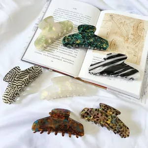 Selection of elegant French-style large hair claws in various marble and acetate patterns