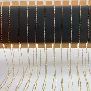 Detailed macro view of multiple gold-colored stainless steel lip chains on a wooden stand