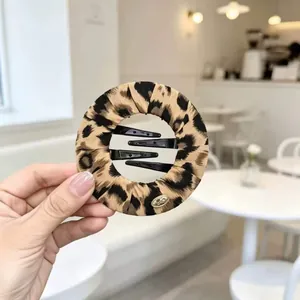 Fermaglio per capelli circolare leopardato per acconciature senza tracce.