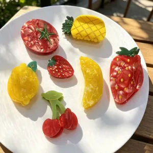 Colorful summer fruit acetate shark hair clips set displayed on a white plate outdoors