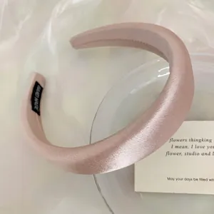 Close-up detail of a soft Morandi pink satin padded headband with high cranial top effect