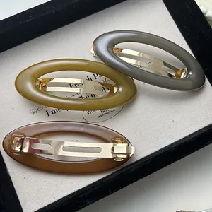 Three vintage oval acrylic hair barrettes for women with elegant gold-tone metal spring clips