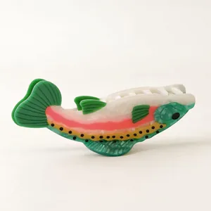 Detail view of a fish-shaped acetate hair claw clip with colorful rainbow trout pattern.