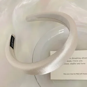 Close-up of elegant cream satin padded headband for high cranial top effect