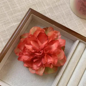 Vue détaillée d'une pince à cheveux pivoine rouge rétro dans une boîte à bijoux élégante
