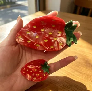 Macro view of strawberry-shaped acetate hair claw clips showing texture and size