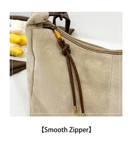 Détail du zip doré fluide sur un sac à bandoulière en daim beige de haute qualité
