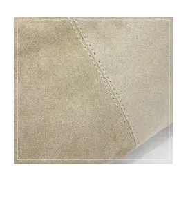 Macro d'un tissu en daim beige de haute qualité avec des coutures blanches fines.