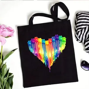 Stylish black canvas tote bag featuring a vibrant rainbow paw print heart graphic design