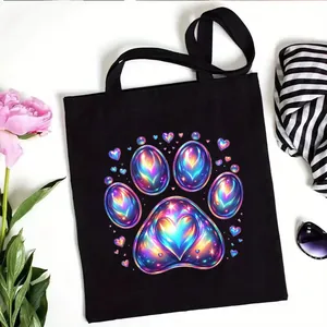 Black canvas tote bag with iridescent paw print and heart design for daily shopping
