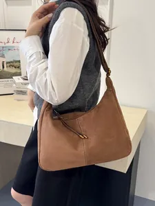 Sac fourre-tout hobo marron en daim de grande capacité porté à l'épaule par un mannequin