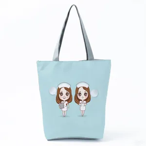 Detailed view of light blue tote bag with cute cartoon nurse print and gray handles.