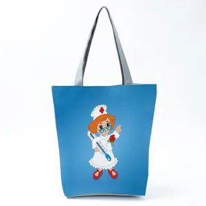 Detail shot of a blue tote bag featuring a cute cartoon nurse print with gray handles.