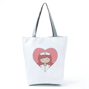 Close-up of white tote bag featuring a cute cartoon nurse heart print design.