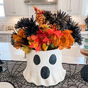 Süße Geister-Vase mit herbstlichem Gesteck und Ahornblättern für die Halloween-Deko