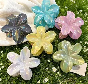 Set of iridescent candy-colored plumeria flower hair claws on green grass