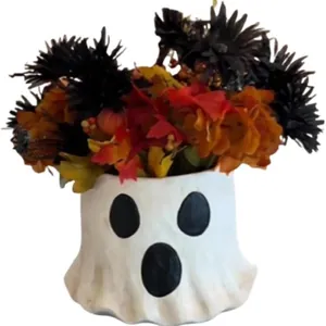 Nahaufnahme eines weißen, gespensterförmigen Blumentopfs mit herbstlichem Laub und Blumen