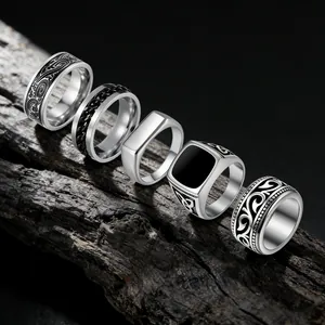 Vintage stainless steel men's ring set featuring engraved scroll and signet designs.