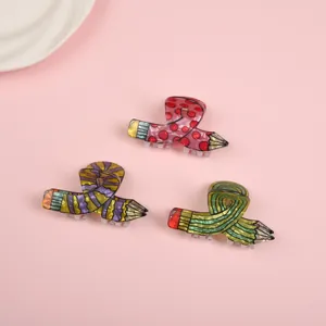 Detail view showing three creative pencil-shaped hair claw clips in various vibrant colors.