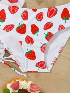 Close-up of girls' strawberry print swimwear bottoms with cute ruffle tie details.