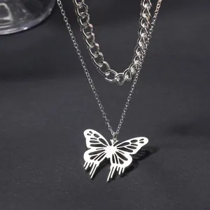 Detailed view of silver butterfly pendant on a double-layered chunky chain necklace