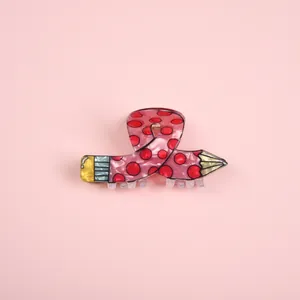 Detailed macro view of a creative pink polka dot pencil-shaped resin hair claw clip.