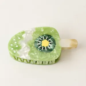 Detailed close-up of a green kiwi fruit ice cream popsicle acetate hair claw clip.