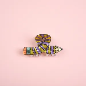 Detailed macro shot of creative pencil shaped hair claw clip in purple and yellow stripes
