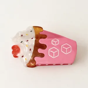 Detail of a whimsical pink ice cream sundae shaped acetate hair claw clip with a cherry top