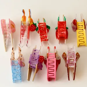 Detailed view of colorful fruit and ice cream themed acetate hair claw clips for women.