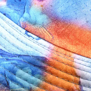 Detailed macro shot of the colorful tie-dye pattern and stitching on a canvas bucket hat