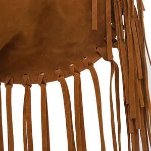 Detailed macro shot of long brown suede fringes on a retro Bohemian style shoulder bag