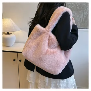 Detail view of a pink fuzzy plush tote bag styled on a model's shoulder for winter.