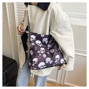 Detail shot of a large tote bag with edgy skull and floral print worn by a model