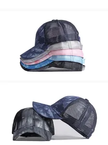 Dettaglio ravvicinato dei motivi tie-dye sfumati sui berretti da baseball traspiranti.