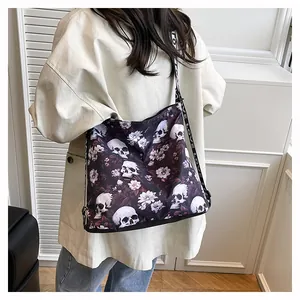 Close-up of a trendy large tote bag with skull and flower patterns on a model's shoulder