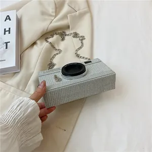 Detailed view of silver glitter camera-shaped box clutch bag with elegant chain strap