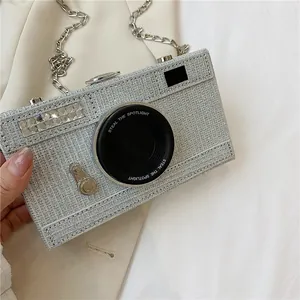Close-up of a silver glitter camera-shaped box bag with rhinestone details
