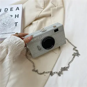 Close-up detail of creative camera-shaped box bag with silver glitter and metal chain