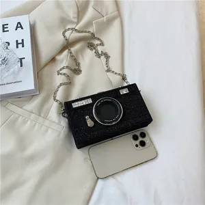 Close-up view of a creative camera-shaped black glitter box bag with silver chain strap
